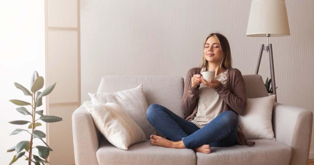 lady sat on sofa enjoying hot drink